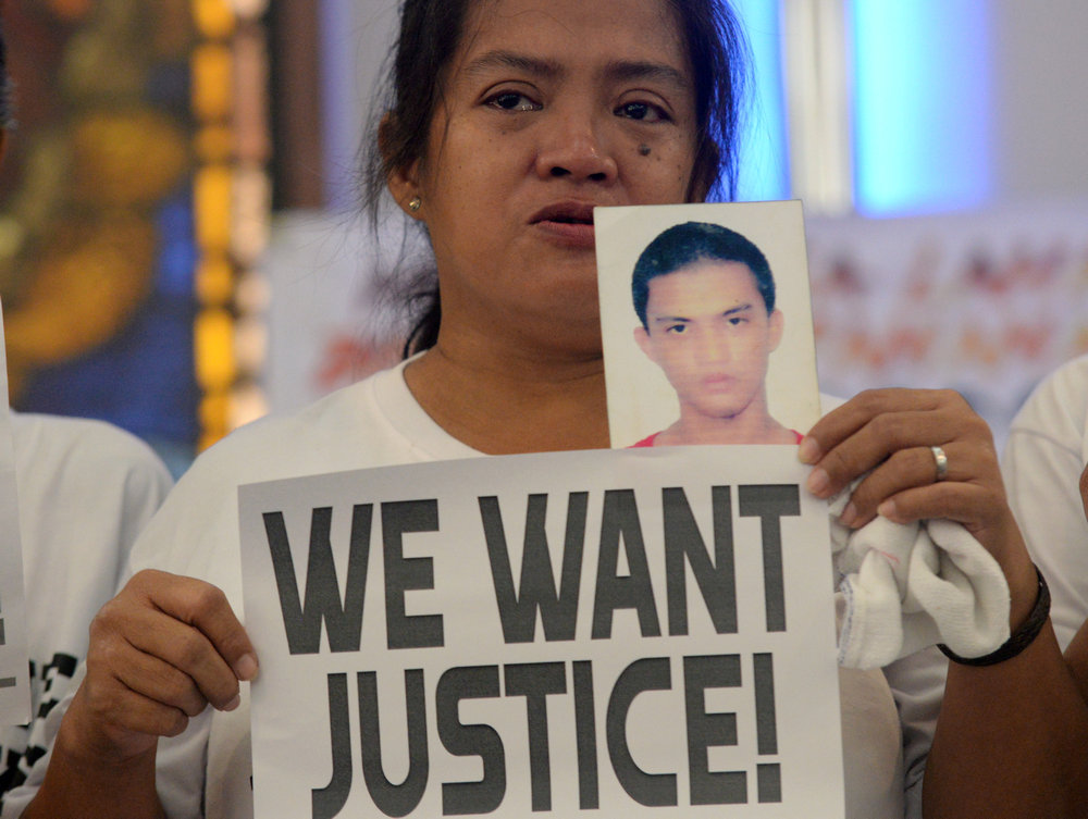 A woman displays a picture of her son, a drug war victim, and a placard during a protest against the war on drugs by Philippine President Rodrigo Duterte in Manila August 28, 2018. u00e2u20acu201d Reuters pic