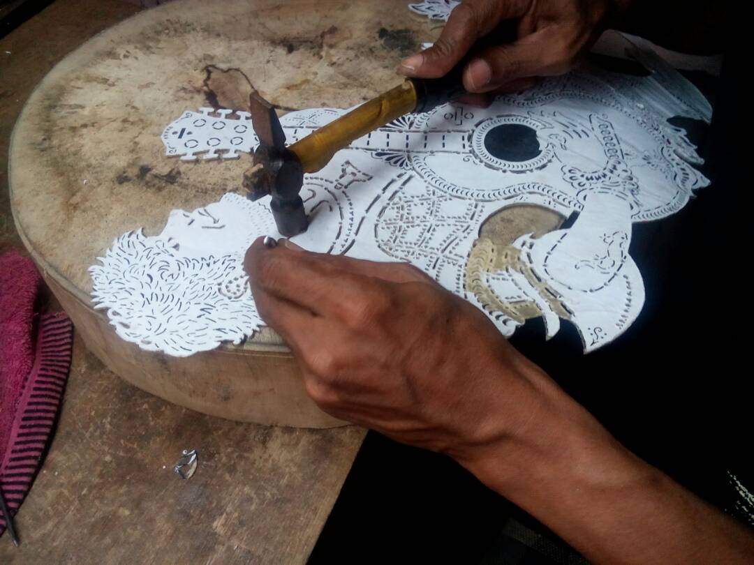 The puppet is cut in the traditional way using a hammer and a nail. 