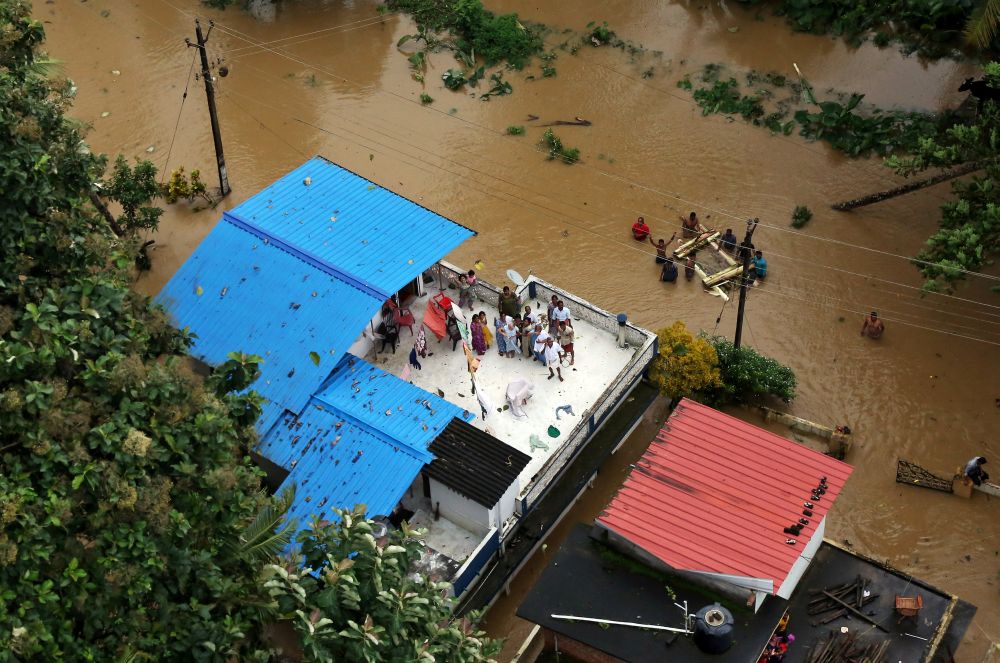 People wait for aid on the roof of their house at a flooded area in the southern state of Kerala August 17, 2018. u00e2u20acu2022 Reuters pic