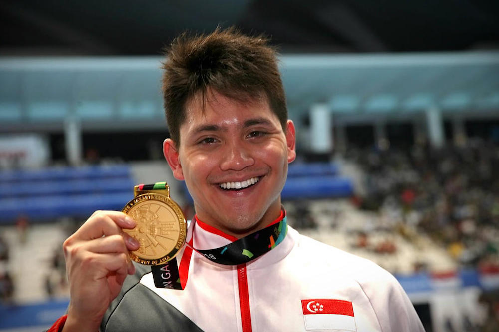 Joseph Schooling holds out his gold medal after coming in first during the menu00e2u20acu2122s 50m butterfly at the 2018 Asian Games in Jakarta August 23, 2018. u00e2u20acu201d TODAY pic