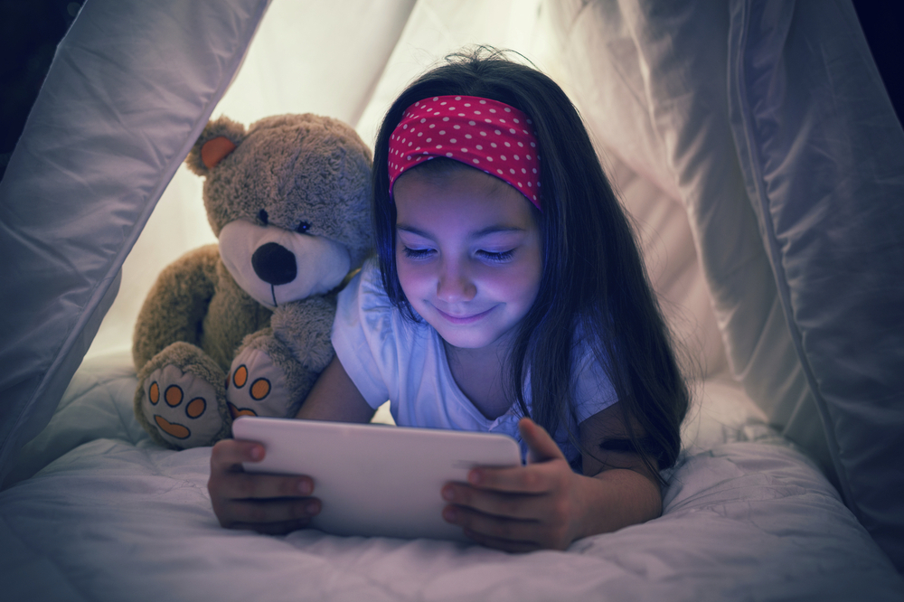 Encouraging kids to avoid using electronic devices in the dark is one way to limit the potential damage caused by too much screen time. u00e2u20acu201d gordana jovanovic/Istock.com pic via AFP