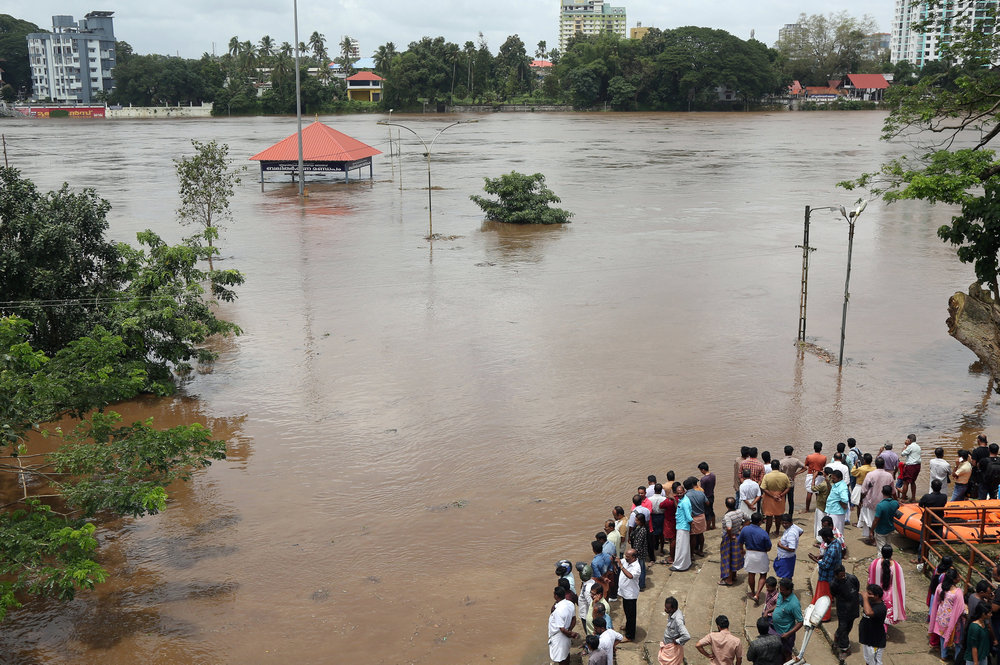 People stand on the steps of Aluva Shiva Temple complex submerged in water after the opening of Idamalayar dam shutter following heavy rains, on the outskirts of Kochi, India August 9, 2018. u00e2u20acu201d Reuters pic
