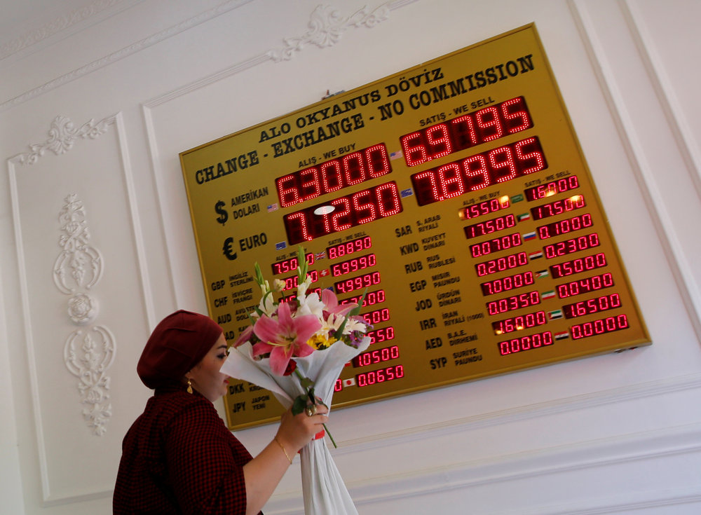 A woman walks past by a board showing the currency exchange rates at currency exchange office in Istanbul, Turkey August 13, 2018. The plunging lira is a source of considerable carnage in emerging markets. u00e2u20acu201d Reuters pic n