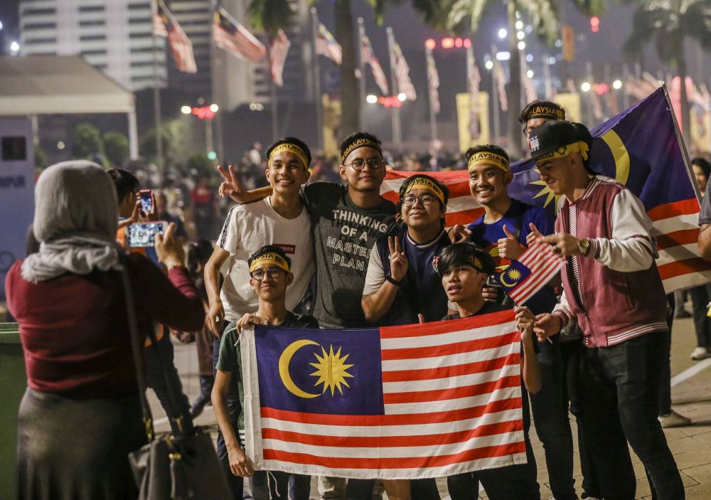 People pose for a picture with the Jalur Gemilang at Dataran Merdeka, Kuala Lumpur during Merdeka Eve in conjunction with Malaysiau00e2u20acu2122s 61st anniversary August 30, 2018. u00e2u20acu201d Picture by Firdaus Llatif