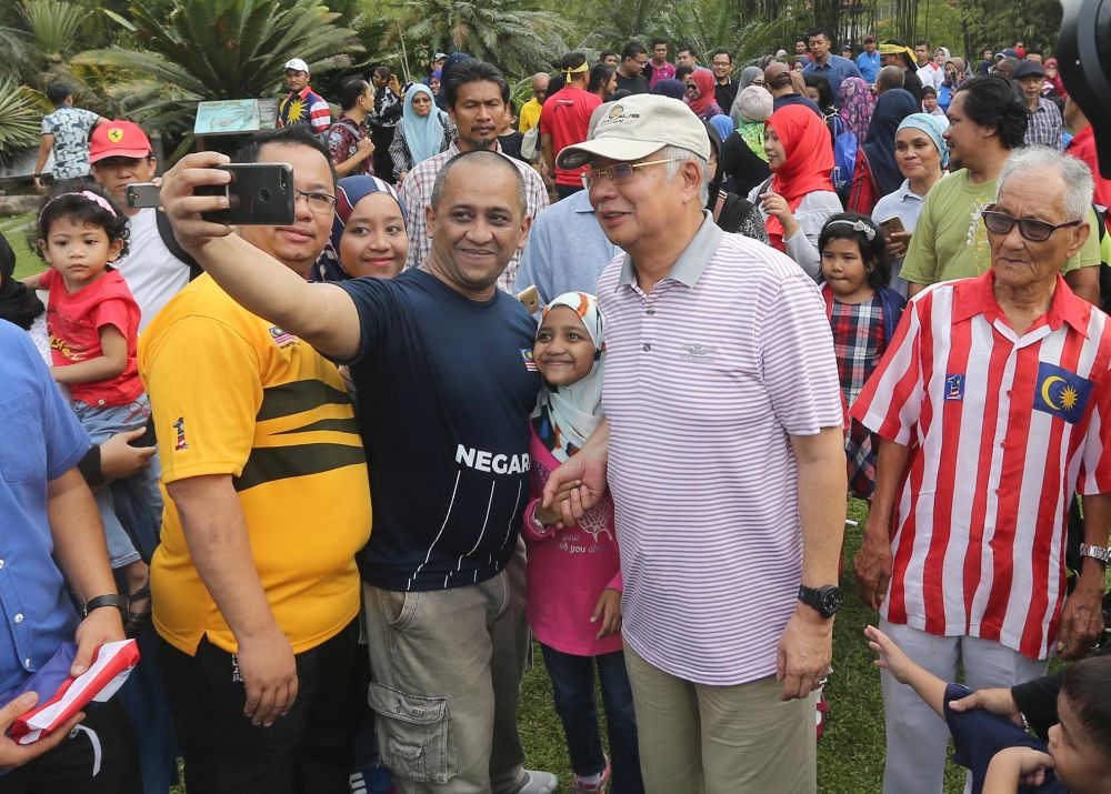 Najib poses for a picture with members of the public at the Perdana Botanical Gardens in Kuala Lumpur August 31, 2018. u00e2u20acu201d Picture by Razak Ghazali