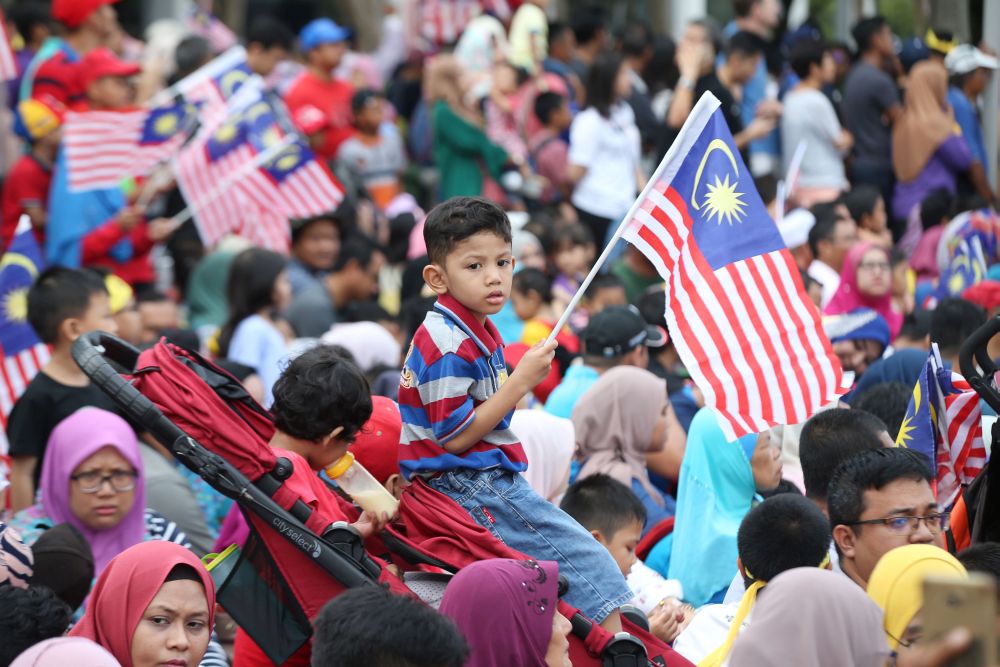 A child is pictured waving the 'Jalur Gemilang' at Dataran Putrajaya August 31, 2018. u00e2u20acu201d Picture by Azinuddin Ghazali