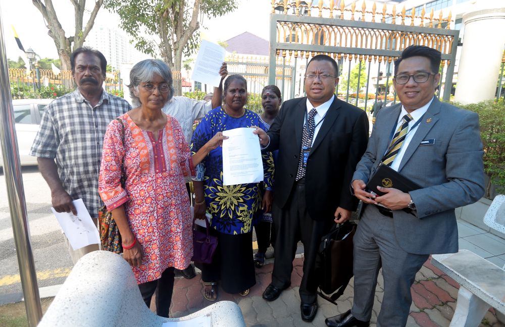 Parti Sosialis Malaysia central committee member R. Mohanarani (in red) hands over the memorandum to the mentri besar's private secretary Nizran Noordin (second right) in Ipoh August 7, 2018. u00e2u20acu2022 Picture by Farhan Najib