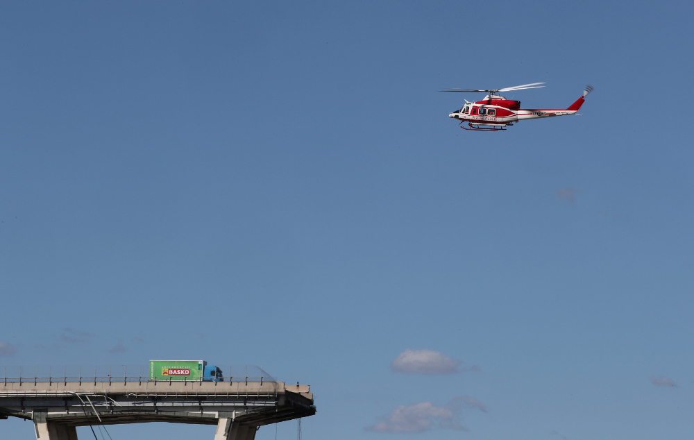 Firefighter helicopter flies over the collapsed Morandi Bridge in the Italian port city of Genoa August 15, 2018. u00e2u20acu201d Reuters pic