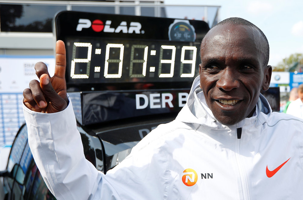 Kenyau00e2u20acu2122s Eliud Kipchoge celebrates winning the Berlin Marathon, alongside a clock showing his World Record breaking time, September 16, 2018. u00e2u20acu201d Reuters pic