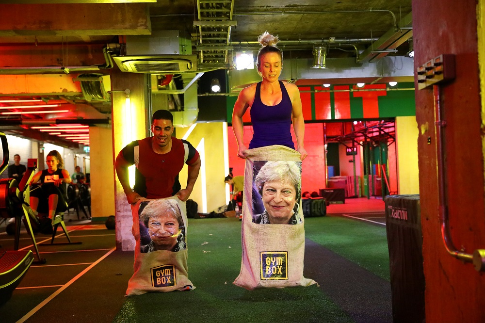 Gym members jump in sacks containing an image of Britain’s Prime Minister Theresa May during a Brexfit gym class at Gym Box in London September 27, 2018.
