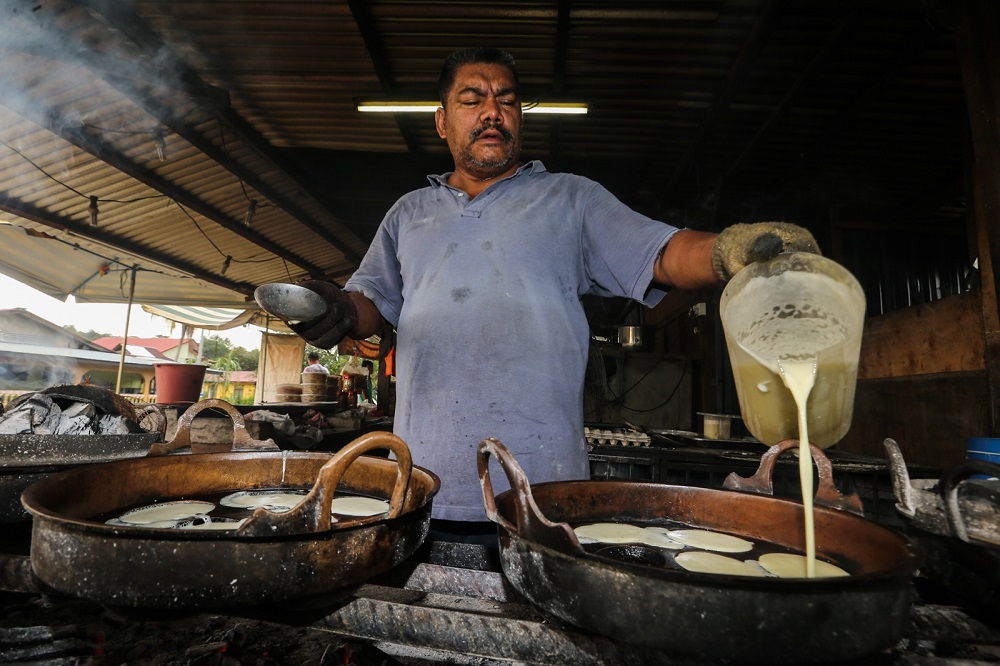 Mohd Ridzuan Rahmat, 52, prepares akok and a variety of other local kuih at his stall in Hulu Langat August 28, 2018.