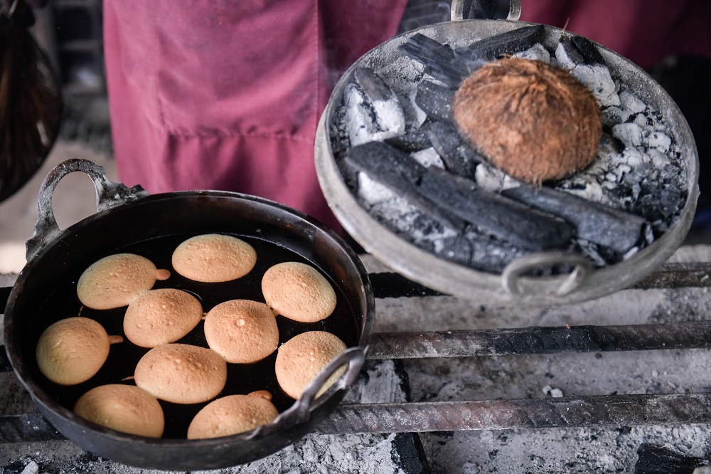 Akok batter is poured into copper moulds and baked over a stove fired by charcoal or coconut husk.