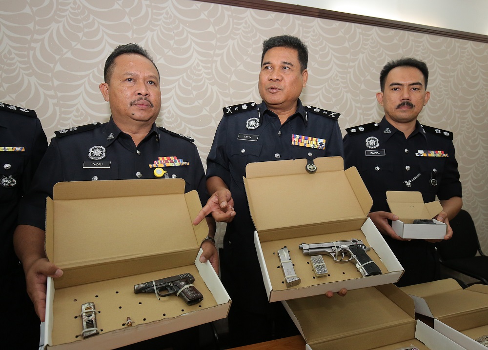 Perak Criminal Investigation Department chief Senior Asst Comm. Yahya Abd Rahman (centre) showing the firerams seized by police while investigating the fatal shooting of a security guard last week. u00e2u20acu201d Picture by Marcus Pheong