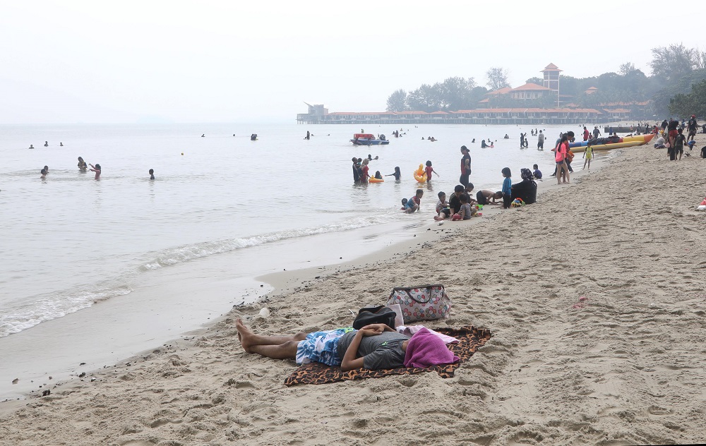 Beach goers at Telok Kemang in the coastal town of Port Dickson. u00e2u20acu201d TODAY pic