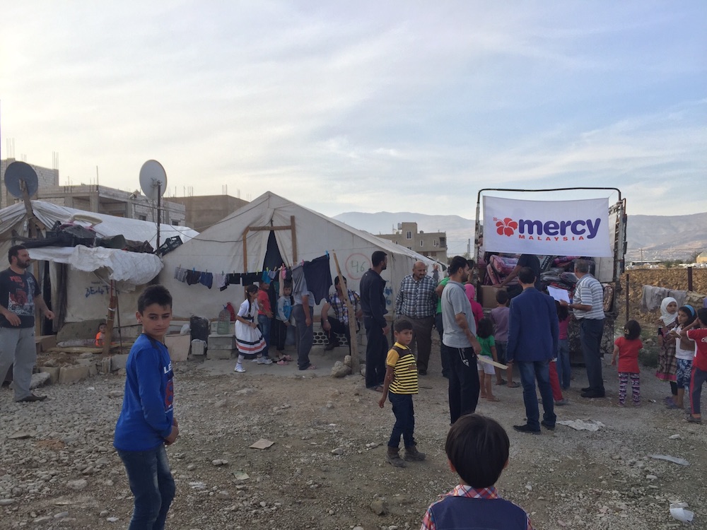 Syrian refugees in Lebanon collecting aid from a Mercy camp in 2015.