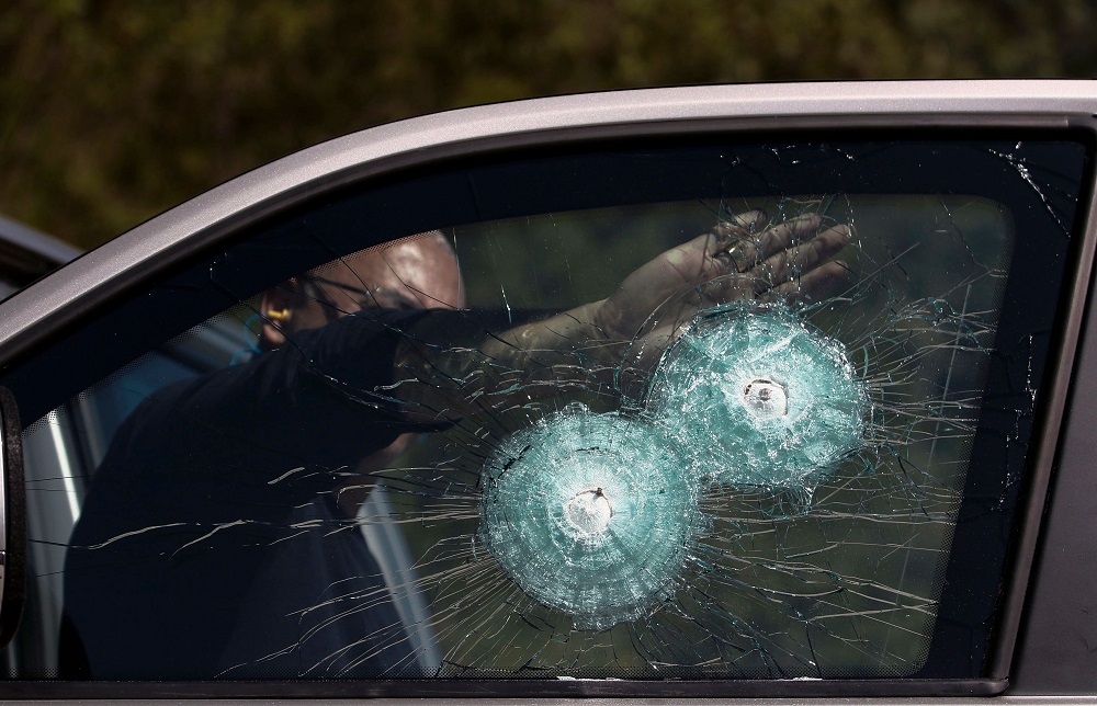 In this file photo taken on December 15, 2017, a technician points at the shot of a .357 Magnum at the window of an armoured car, at a company in Maua, Sao Paulo, Brazil. u00e2u20acu201d AFP pic 
