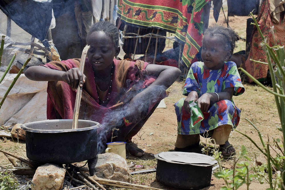 An Ethiopian girl prepares food for her family at Sesion camp for refugees at Kenyau00e2u20acu2122s border town with Ethiopia, Moyale, about 779 kilometres north of capital Nairobi, on March 17, 2018 after fleeing Ethiopia. u00e2u20acu201d AFP pic