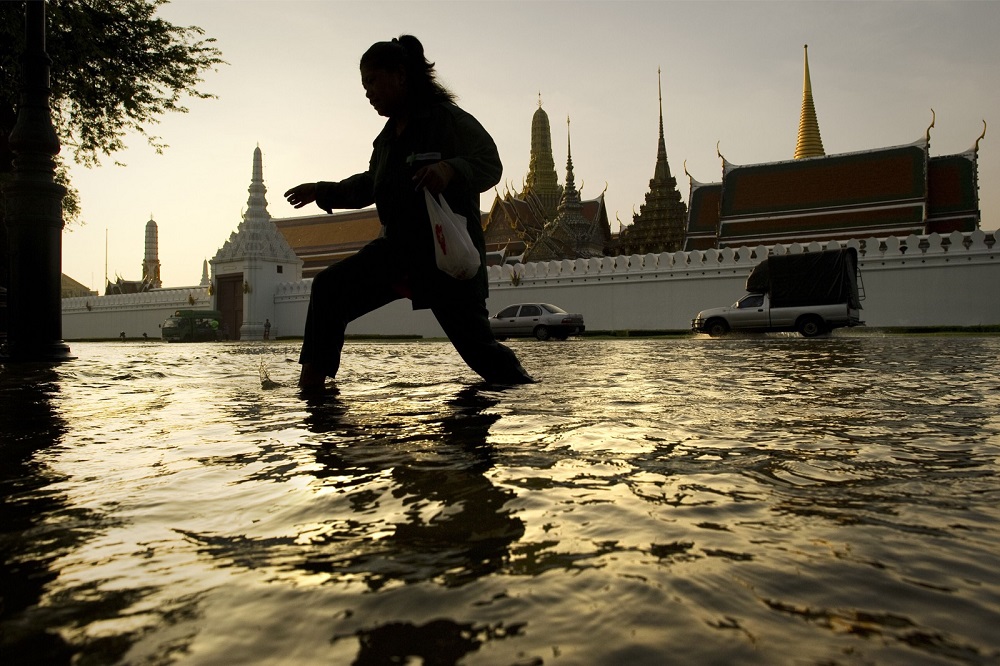 This file photo taken on October 28, 2011 shows a woman walking through floodwaters in front of the Grand Palace near the Chao Praya river in Bangkok. u00e2u20acu201d AFP pic