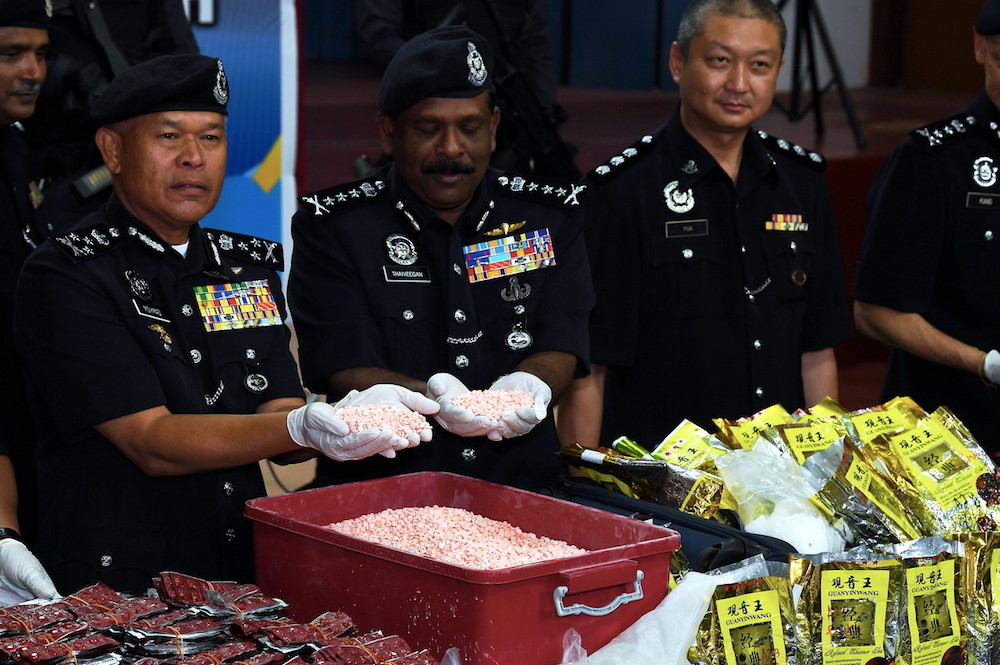Bukit Aman Narcotic Criminal Investigation Department director Datuk Seri Mohmad Salleh (left) holds some of the seized Eramin 5 pills during a press conference in Bukit Mertajam September 14, 2018. u00e2u20acu201d Bernama pic