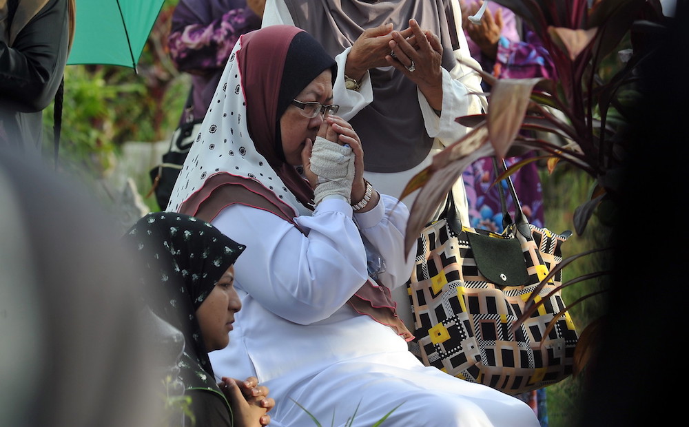 Datin Seri Rabaayah Md Naim prays during the funeral of her husband Datuk Seri Abdul Rashid Abdullah at the Sungai Bakap Muslim Cemetary in Nibong Tebal September 20, 2018. u00e2u20acu201d Bernama pic