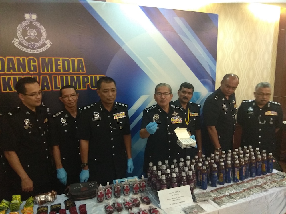 Datuk Seri Mazlan Lazim holds a ganja cigarette that was sold for RM70 per stick in entertainment outlets. u00e2u20acu201d Picture by Kenneth Tee