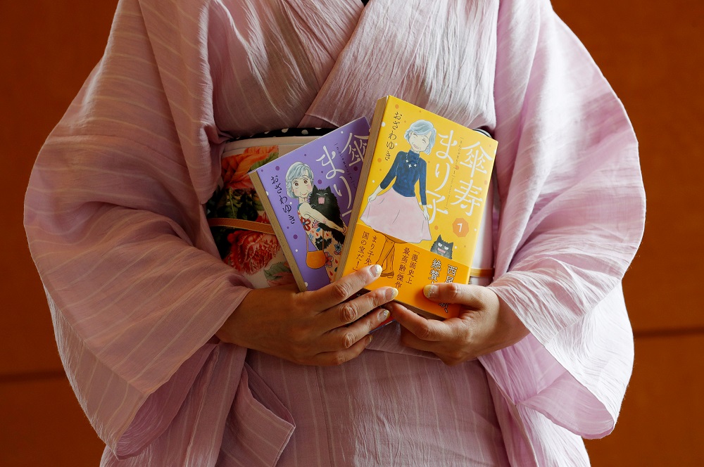 Yuki Ozawa, the comic book author of u00e2u20acu02dcSanju Marikou00e2u20acu2122, poses with her comic books during an interview with Reuters in Tokyo August 16, 2018. u00e2u20acu201d Reuters pic      