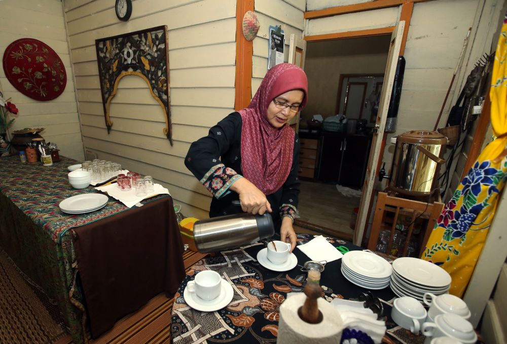 Suka-Suka Lake Retreat co-owner Asiah Mohd Ridzuan, 54, prepares drinks at the dining house. 