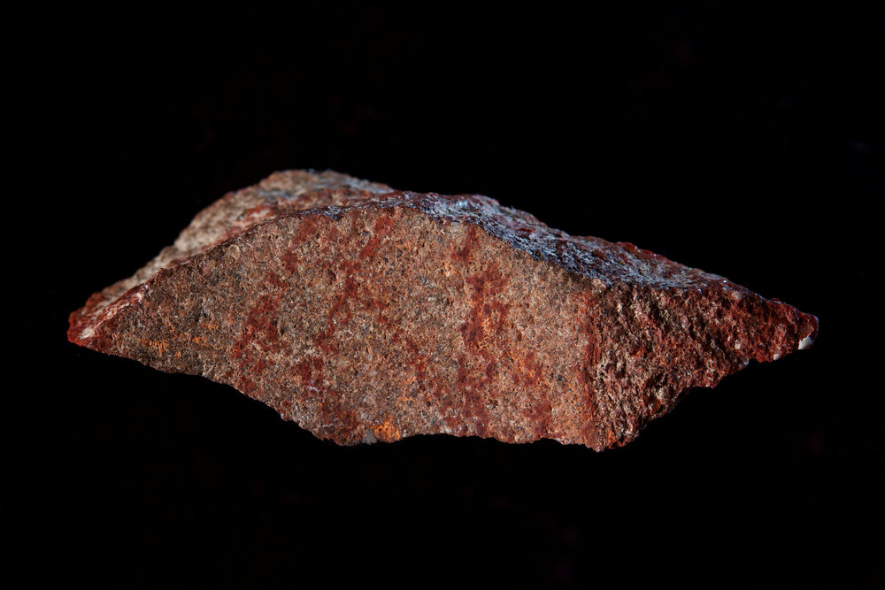 A stone flake discovered in Blombos Cave with red ochre markings that archeologists say represent one of the oldest-known examples of human drawings in this photo released September 12, 2018. u00e2u20acu201d Craig Foster/Handout via Reuters