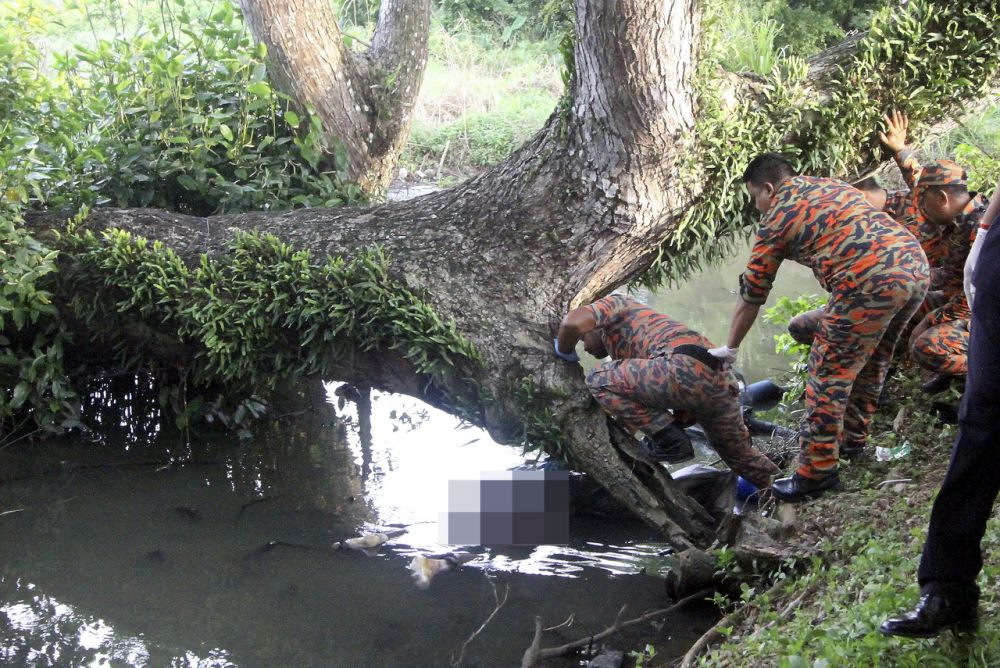 Anggota Bomba mengeluarkan mayat dua mangsa yang terlibat dalam kemalangan seminggu lalu ditemukan di dalam parit di Kampung Sungai Bugis semalam. u00e2u20acu201d Foto Bernama