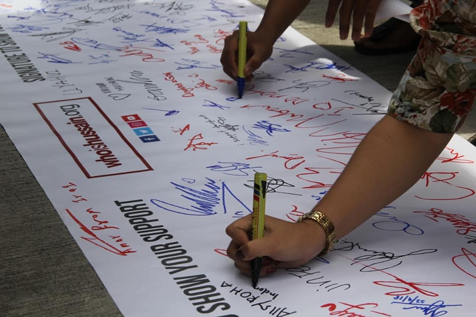 People sign a banner in support of the Who is Hussain charity movement in Bukit Bintang September 22, 2018. ― Picture courtesy of Who is Hussain