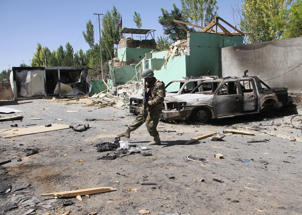 A member of the Afghan security forces stands guard next to damaged army vehicles after a Taliban attack in Ghazni city, Afghanistan August 15, 2018. u00e2u20acu201d Reuters pic
