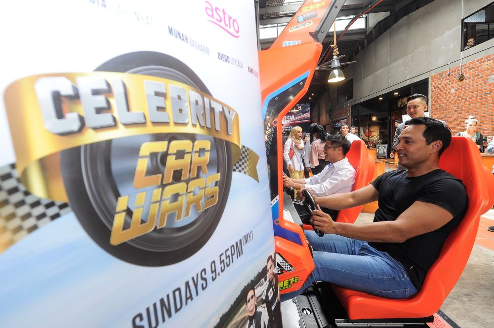 Hans showing his skill racing in the 'Daytona' arcade game at the launch. ― Picture by Shafwan Zaidon