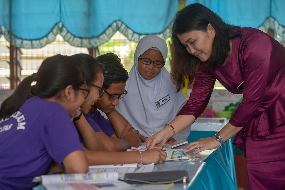 Teacher Tracy Neddy teaches her students after they received their spectacles at SK Atas Singai in Kuching August 29, 2018.