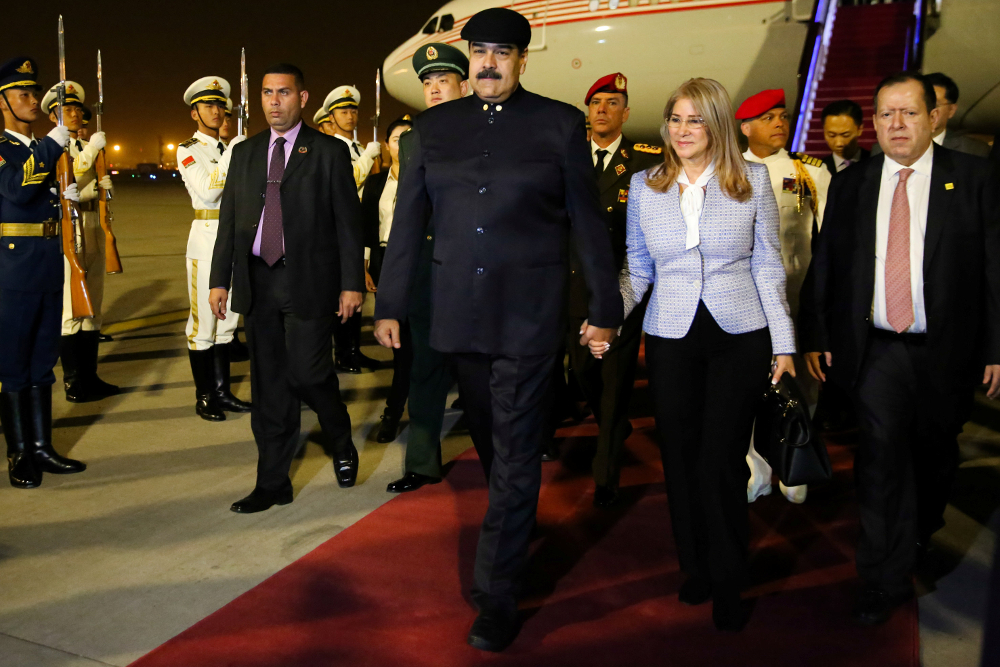 Venezuelau00e2u20acu2122s President Nicolas Maduro walks with his wife Cilia Flores upon their arrival at the airport in Beijing September 13, 2018. u00e2u20acu201d Handout by Miraflores Palace via Reuters