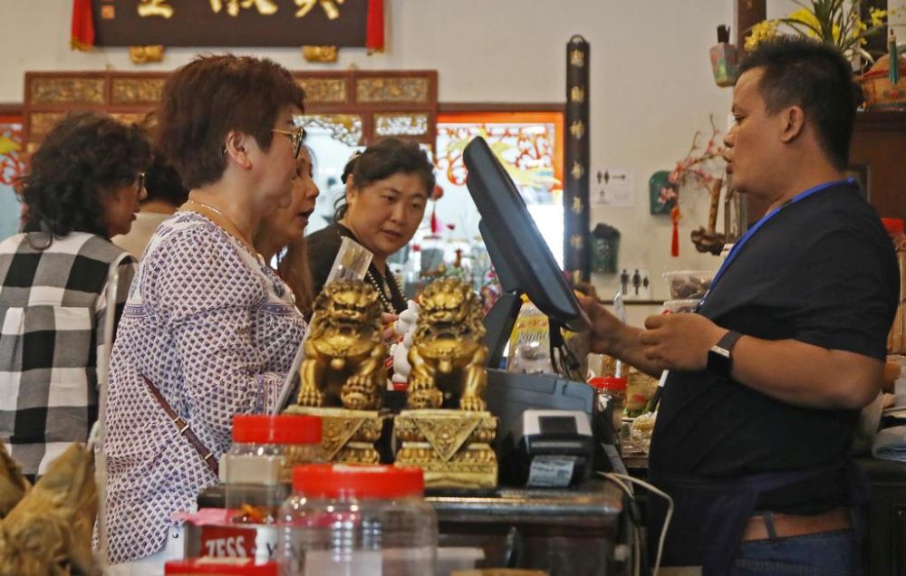 A cashier tallying up purchases from customers. Almost a month after Putrajaya rolled out the new Sales and Services Tax (SST), the full impact is yet to be felt on the ground. u00e2u20acu201d TODAY pic