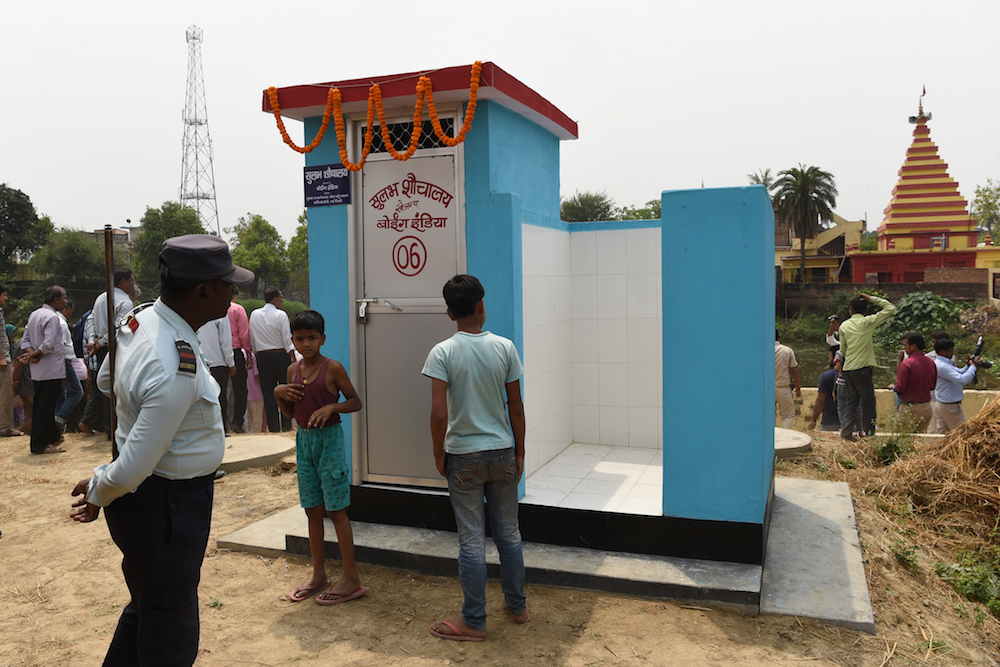 A private security guard and villagers gather around a newly built public toilet by Boeing India, under its Corporate Social Responsibility (CSR) activity, at Sarisabpahi Village in Madhubani district in Bihar April 8, 2018. u00e2u20acu201d AFP pic