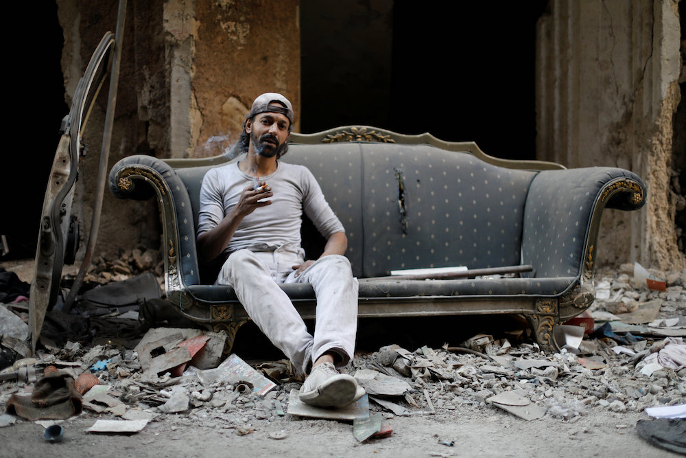 Abu Nimr smokes a cigarette as he sits on a sofa along a damaged street in Yarmouk Palestinian camp in Damascus October 10, 2018. u00e2u20acu201d Reuters pic