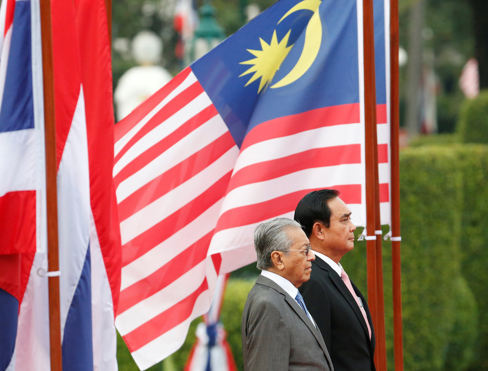 Tun Dr Mahathir Mohamad and Gen Prayut Chan-o-cha listen to their national anthems during a welcoming ceremony in Bangkok October 24, 2018. u00e2u20acu201d Reuters pic