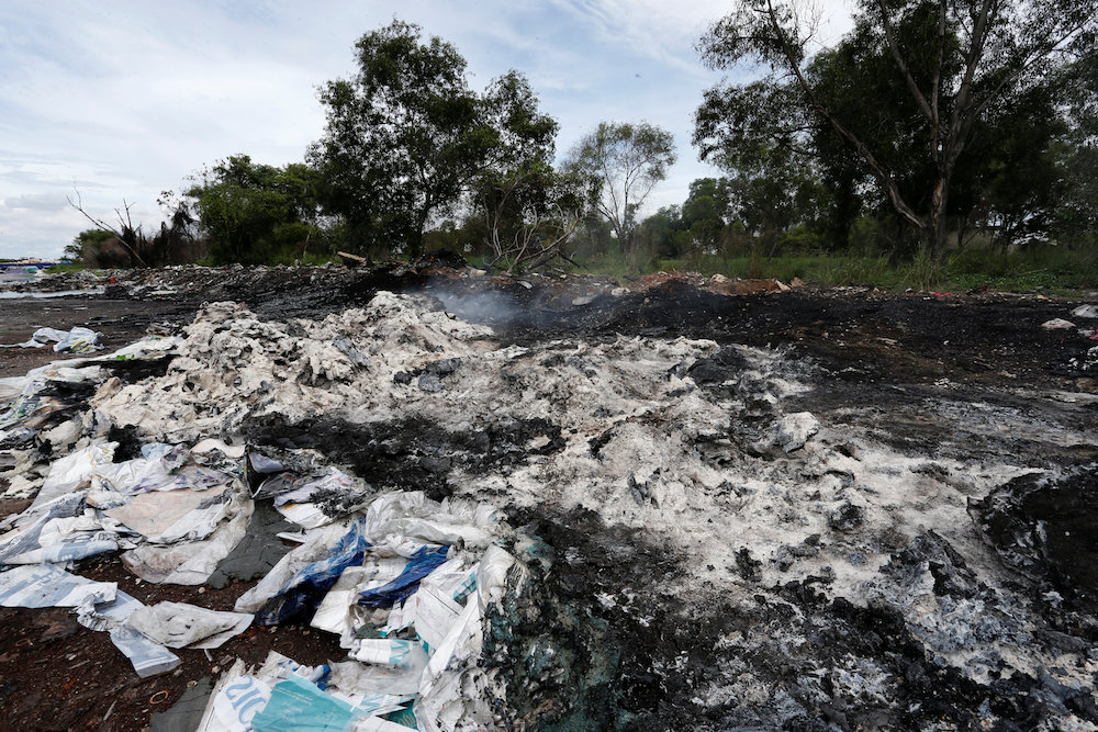 Burnt plastic waste from open burning is pictured on the roadside in Pulau Indah October 14, 2018. — Reuters pic