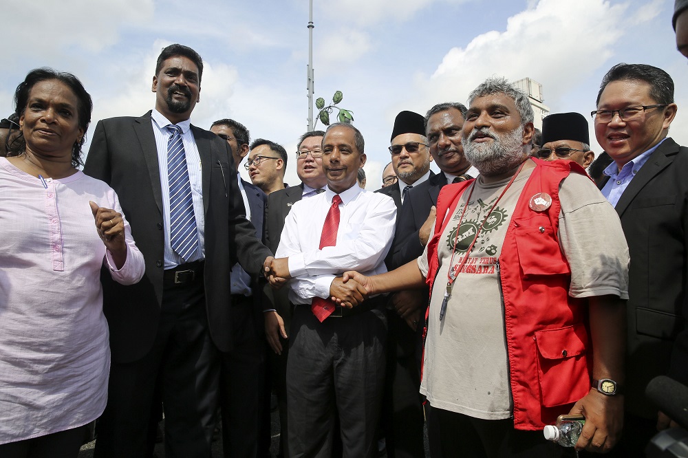 Human Resources Minister M. Kulasegaran (centre) shakes hand with MTUC president Datuk Abdul Halim Masnor (left) and PSM member S. Arutchelvan outside the Parliament building in Kuala Lumpur October 17, 2018. u00e2u20acu201d Picture by Yusof Mat Isa