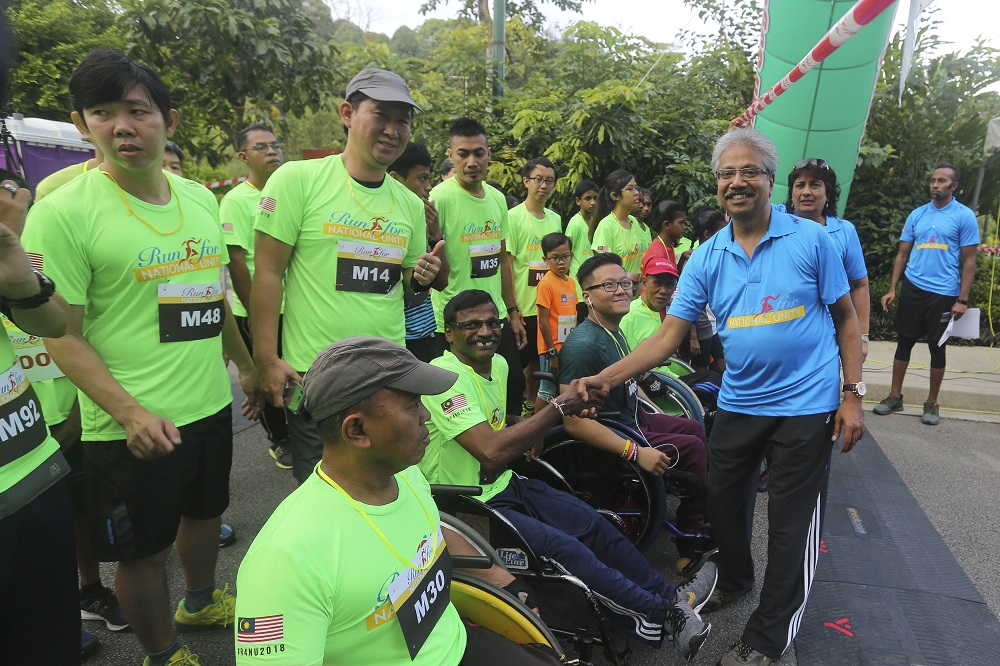 P. Waythmoorthy (right) greets participants of the Run for National Unity event at Perdana Botanical Gardens in Kuala Lumpur October 20, 2018.
