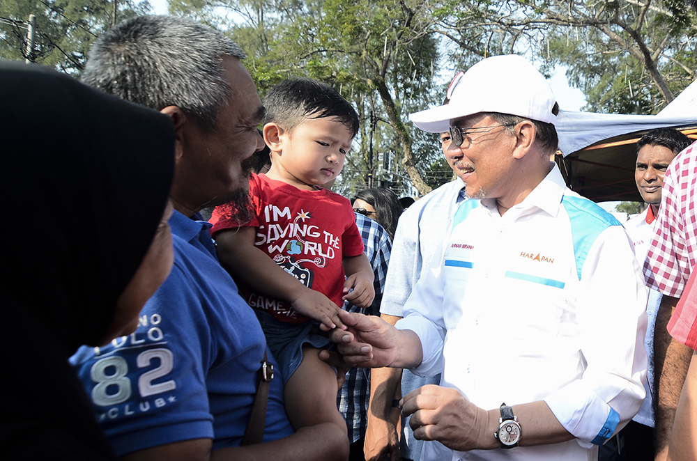 Datuk Seri Anwar Ibrahim interacts with people during a campaign walkabout at the Batu 4 Wet Market in Port Dickson October 3, 2018. — Picture by Miera Zulyana
