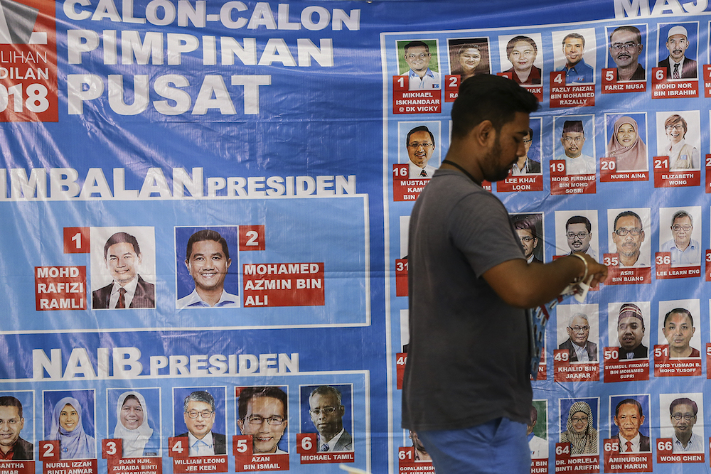 A man walks past a poster of PKR candidates during the Federal Territories PKR election in Kepong October 7, 2018. u00e2u20acu201d Picture by Azneal Ishak