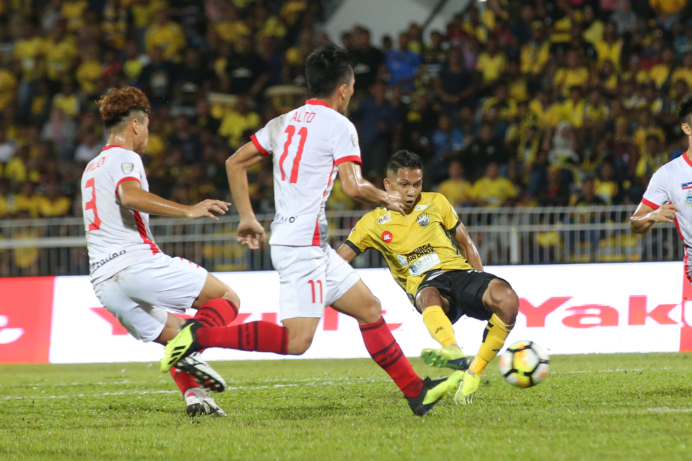Peraku00e2u20acu2122s Nor Hakim Hassan (yellow) shoots the ball in the match against Sabah in the Malaysia Cup semi-final first leg at Perak Football Stadium October 7, 2018. u00e2u20acu201d Picture by Marcus Pheong