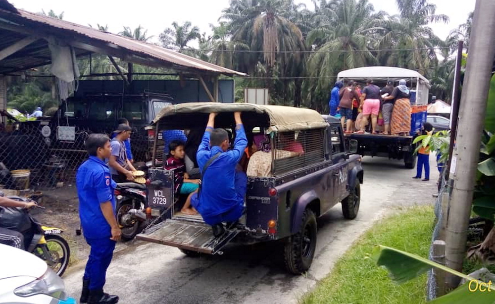Civil Defence Force personnel evacuate Changkat Jong after three villages were flooded this morning. — Picture courtesy of Perak State Disaster Management Commission