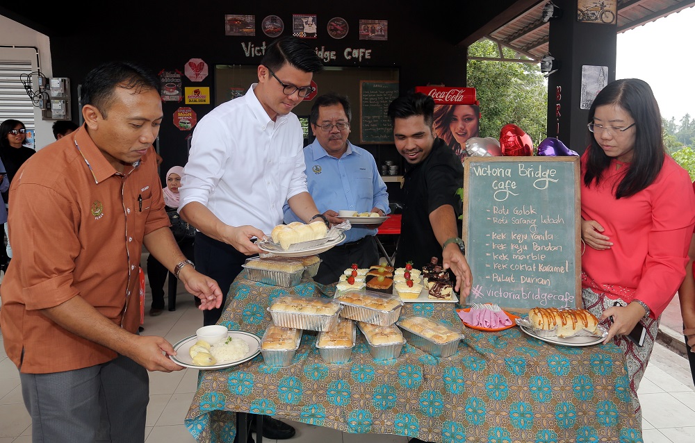State tourism, arts and culture committee chairman Tan Kar Hing (second left) trying the roti golok at the Victoria Bridge Cafe. u00e2u20acu201d Picture by Farhan Najib