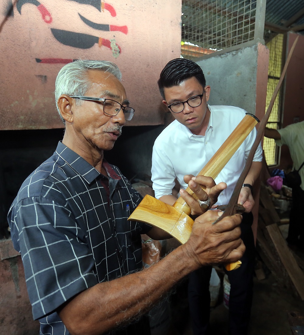 Keris maker Abdul Mazin Abdul Jamil (left) shows off his finish work at Kampung Padang Changkat, Kuala Kangsar.