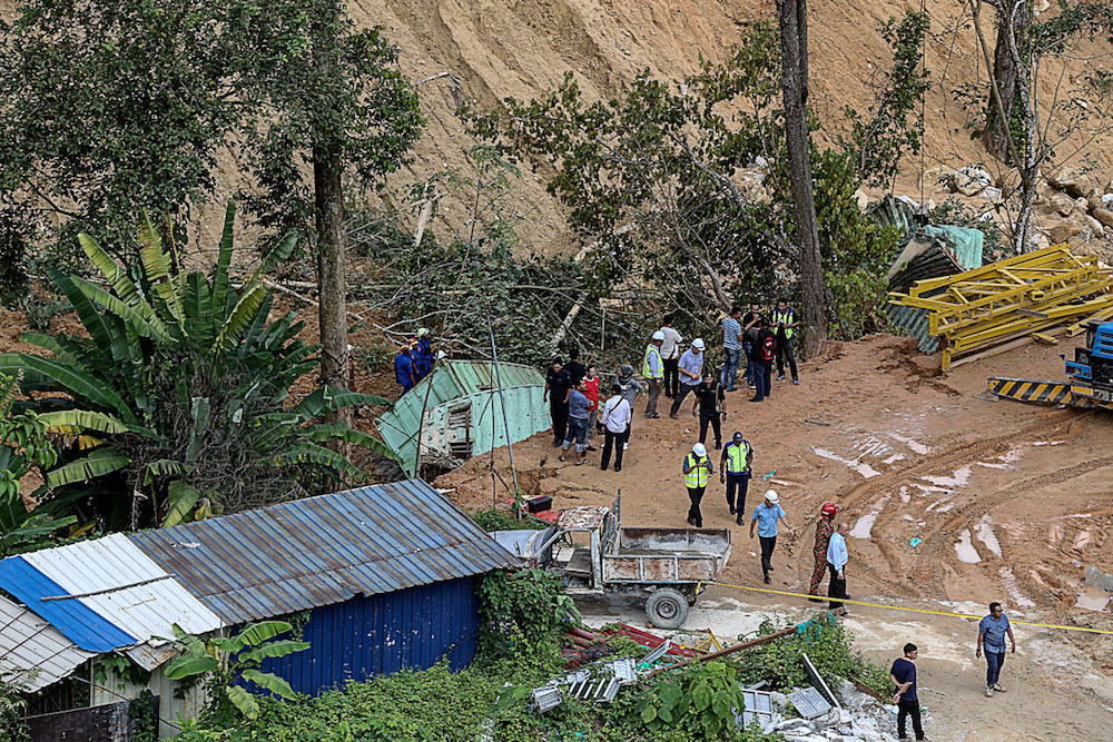 Fire and Rescue and Civil Defence personnel are seen at the construction site between Bukit Kukus and Bukit Paya Terubong where the landslide occurred in Paya Terubong October 19, 2018. u00e2u20acu201d Picture by Sayuti Zainudin