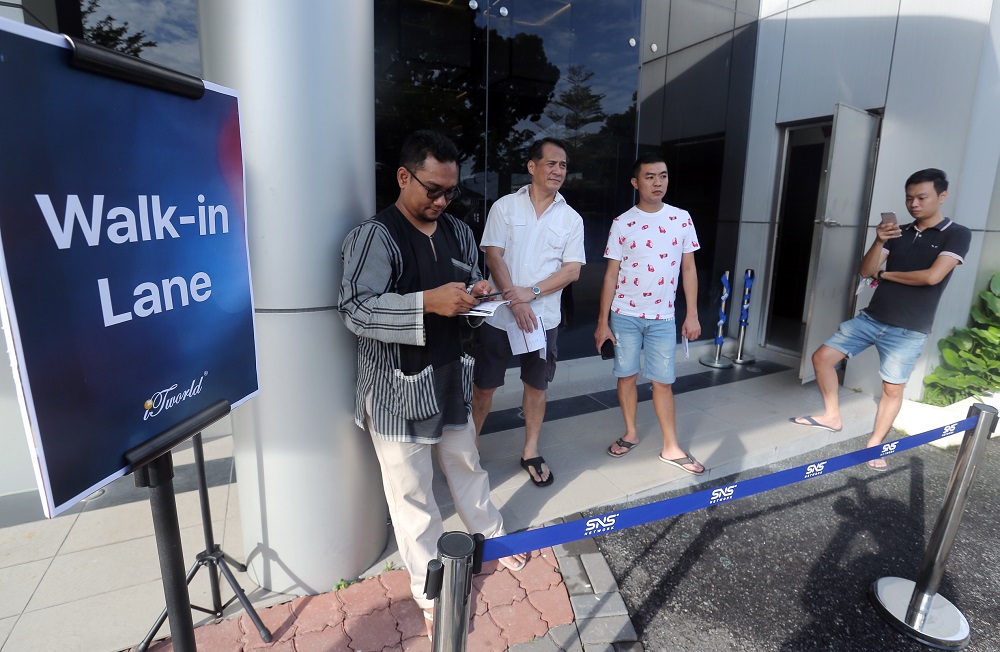 Customers queuing up to purchase the newly launched iPhone XR, XS Max and XS at the SNS Network outlet in Ipoh October 26, 2018. 
