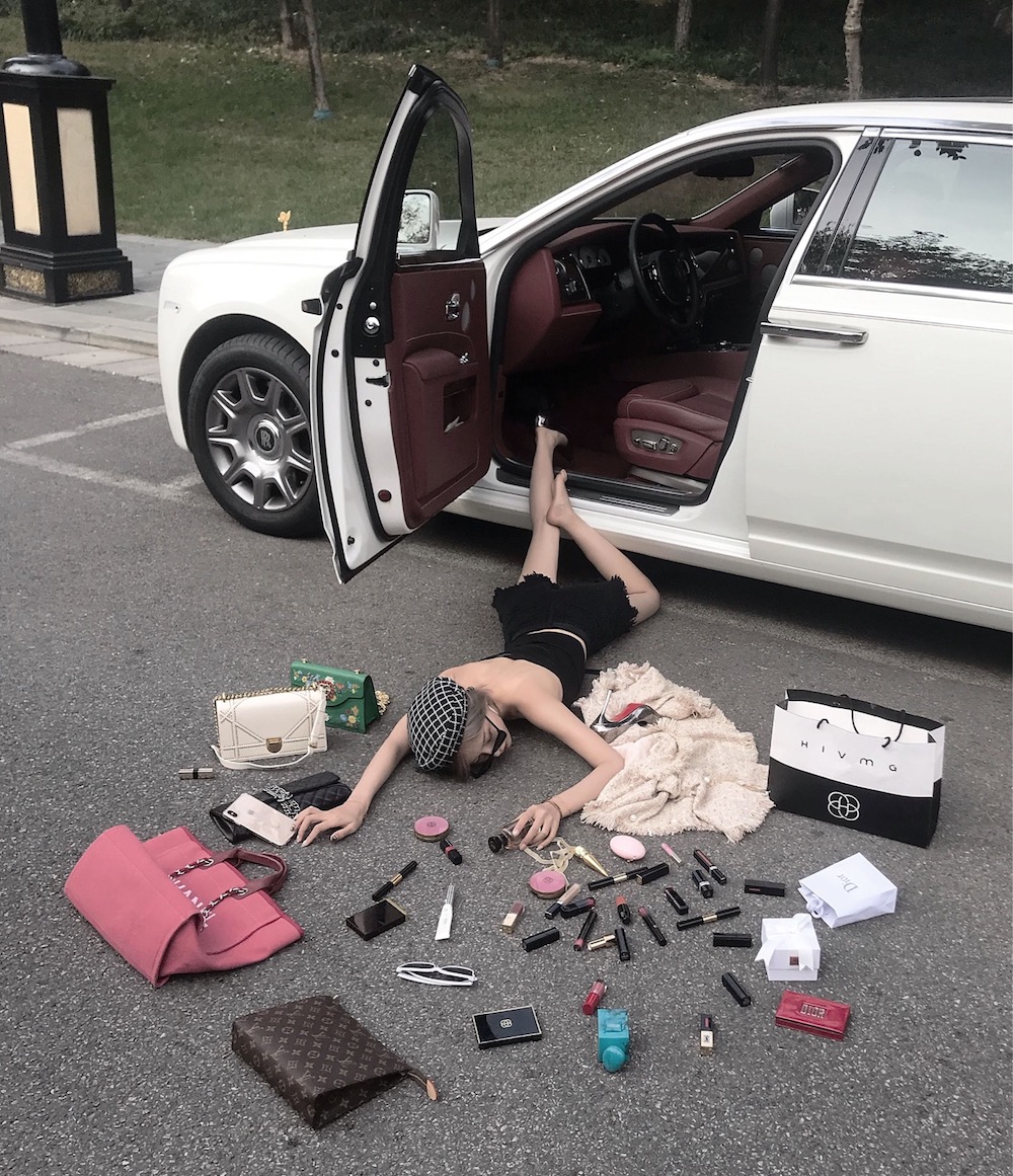 This handout released to AFP today by Wen Siyuan shows a woman lying on the floor as she poses for a picture with lipsticks and handbags in Xiu00e2u20acu2122an. u00e2u20acu201d Wen Siyuan handout via AFP 